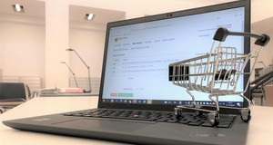 Miniatureinkaufswagen auf der Tastertur eines Laptops der die Internetseite des Stadtarchivs mit der Bestellfunktion zeigt.