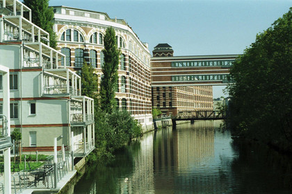 Gebäude der ehemaligen Buntgarnwerk mit dem Fluss Elster daneben.