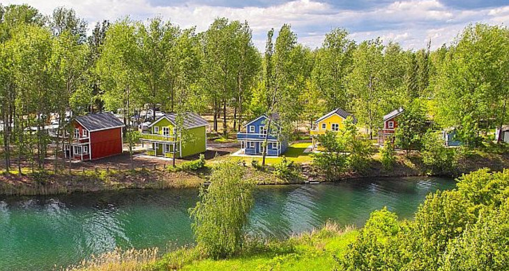 Ferienhäuser zwischen Bäumen auf dem Campingplatz am Kulkwitzer See