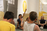 Eine Gruppe von Kindern und Jugendlichen sitzt in der Dauerausstellung des Naturkundemuseums Leipzig und diskutiert angeregt