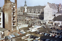 Foto vor dem Jahr 1960. Blick in Richtung Markt mit dem Alten Rathaus. Davor ist eine Ruine sichtbar und ein Parkplatz. Viele Menschen laufen auf den Straßen.