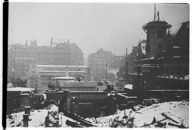 Stark zerstörter Markplatz in Leipzig mit Blick auf das zerbombte Rathaus im Schnee