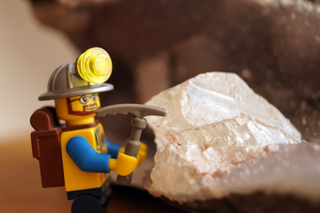 Lego-Figur hämmert an kristallinem Gestein