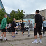 Auf dem Leipziger Augustusplatz steht ein Kreis aus Jugendlichen, die Fußball spielen