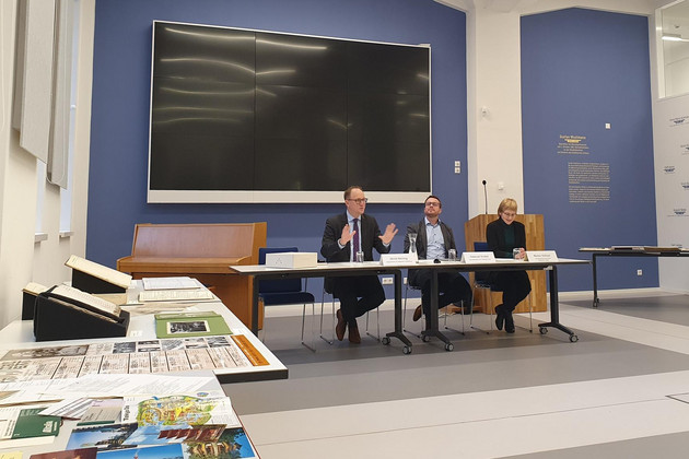 Ulrich Hörning, Emanuel Scobel und Marlen Schnurr sitzen in einem Raum an einem Tisch während einer Pressekonferenz.