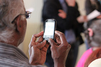 Ein alter Mann von hinten mit Handy in der Hand