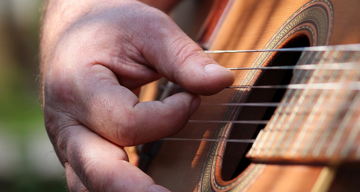 Nahaufnahme einer hand beim Gitarrespielen