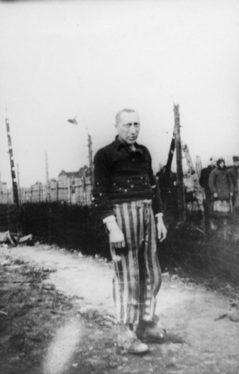Männlicher Häftling in gestreifter Häftlingskleidung aus dem Konzentrationslager mit dunkler Jacke