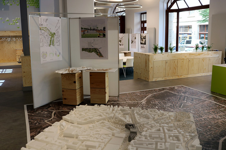 Blick in das Stadtbüro. Im Vordergrund eine Ausstellung von Architekturskizzen und Modellen.