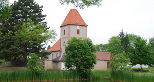 Die Kirche in Baalsdorf. Davor ist ein Teich.