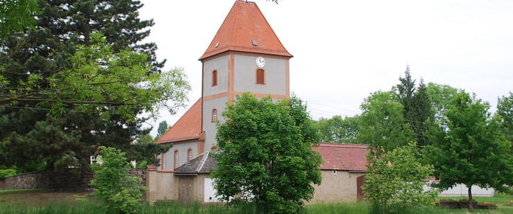 Die Kirche in Baalsdorf. Davor ist ein Teich.