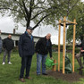 An einem neu gepflanzten Baum stehen Bürgermeister Heiko Rosenthal und vier weitere Männer.