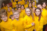 Viele Kinder des Schola Cantorum Kinderchors in gelben T-Shirts
