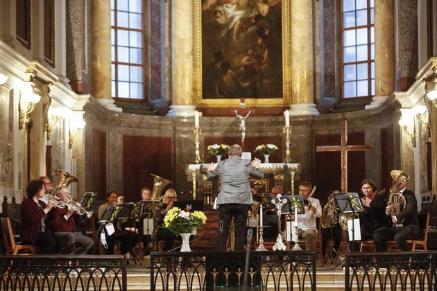 Ein Mann dirigiert Musiker im Altarraum in der Nikolaikirche