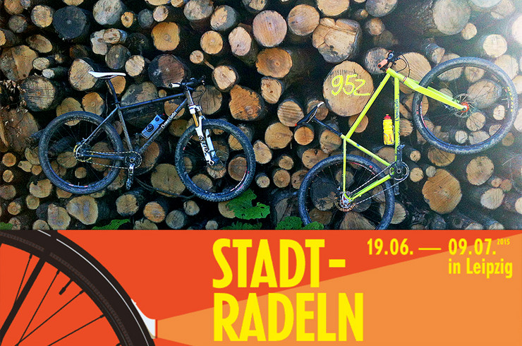 Foto: Zwei Fahrräder hängen in einem Holzstapel. Darunter das Logo Leipziger Stadtradeln.