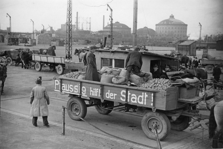 Lastwagen mit Kartoffeln die von Männern ausgeladen werden