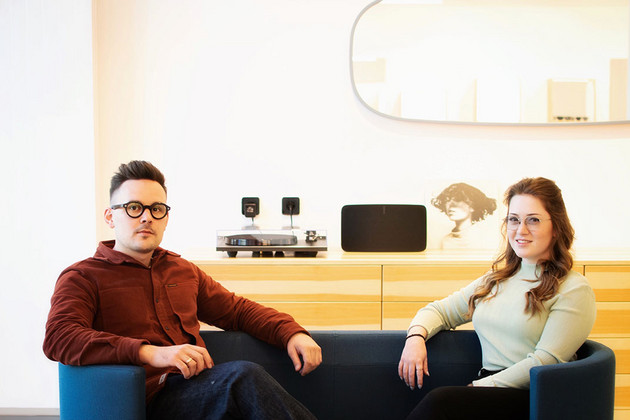 Felix Schneeweiss mit einer Frau auf einem Sofa. Beide tragen Brillen. 