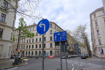Verkehrsschilder weisen verkehrsberuhigten Bereich in einbiegender Straße aus.