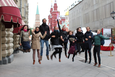 Eine Gruppe junger Menschen springt auf einem Fußweg für ein Foto in die Höhe.