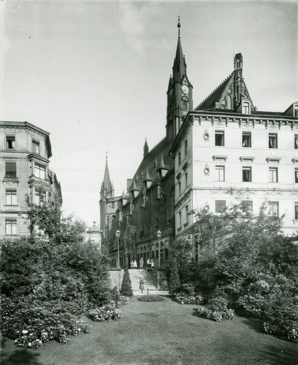 Eine schwarz-weiß Fotografie aus dem Jahr 1911. Im Vordergund ist eine Rasenfläche und Bepflanzung. Im Hintergrund steht die Matthäikirchhe.