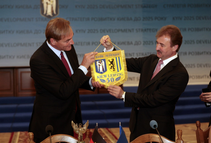Leipzigs Oberbürgermeister Jung und Kyjiwd Bürgermeister Popov halten ein Wimpel mit den Wappen Kiews und Leipzigs gemeinsam in den Händen