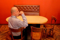 Ein Mann sitzt allein an einem Tisch und trinkt einen Schnapps
