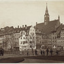Auf der alten Fotografie stehen Personen an einem Geländer. Im Hintergrund steht die Matthäikirche.