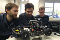 Studierende der HTWK Leipzig schauen ihr Modellauto an