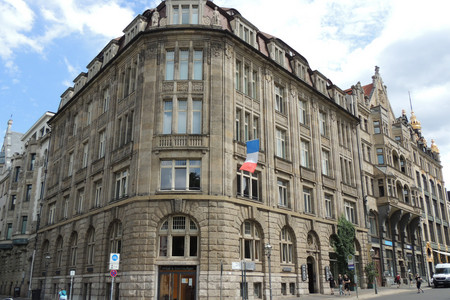 Eckhaus, an dem in der ersten Etage eine französische Flagge in den Farben blau-weiß-rot weht