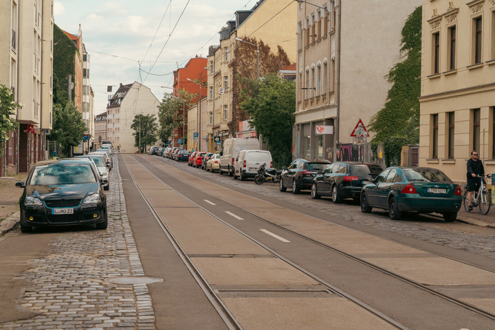 Die Dieskaustraße mit vielen parkenden Autos rechts und links am Straßenrand.