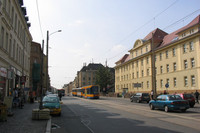 Georg Schumann Straße mit Straßenbahn und fahrenden sowie parkenden Autos