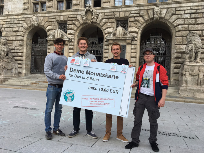 Vier Mitglieder des Jugendparlamentes vor dem Neuen Rathaus. In ihren Händen ein großes Schild: Deine Monatskarte für Bus und Bahn maximal 10 Euro.