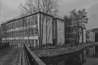 Schwarz-Weiß-Foto mehrere Blockbauten an einem Kanal