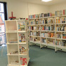 Zeitschriftenbereich der Bibliothek mit vielen gefüllten Bücherregalen im Hintergrund.