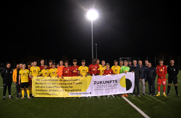 Zwei Jugend-Fußballmannschaften stehen hinter einem Banner für das Zukunftszentrum