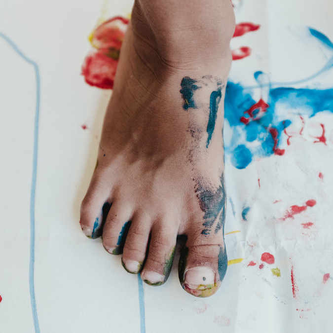 Nackter Fuß mit Farben bespritzt