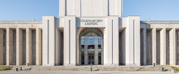 Frontalansicht des Stadtarchivs mit Kollonaden, Eingangsportal und goldener Spitze