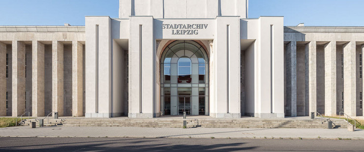 Frontalansicht des Stadtarchivs mit Kollonaden, Eingangsportal und goldener Spitze