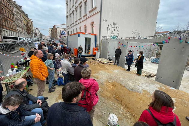 Besucherinnen und Besucher stehen auf der Baustelle in der Braustraße in Leipzig bei der Grundsteinlegung