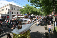 Blick über die Parade des Straßenfestes Bohei & Tamtam auf der Karl-Heine-Straße. Viele Künstler und Menschen laufen auf der Straße entlang.