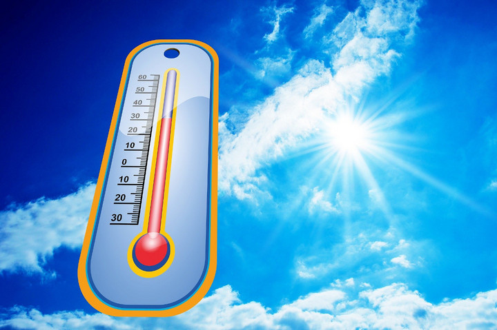 Ein Thermometer, das über 30 Grad anzeigt. Im Hintergrund ist ein blauer Himmel und die Sonne scheint.