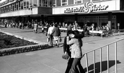 Straßenszene vor dem Restaurant "Stadt Dresden" und dem Freisitz der Milch-Mokka-Eisbar am Wintergartenhochhaus. Zwei Personen küssen sich im Vordergrund