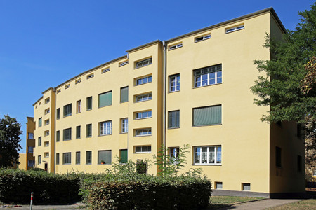 Mehrstöckiger gelber Blockbau mit gewölbter Fassade