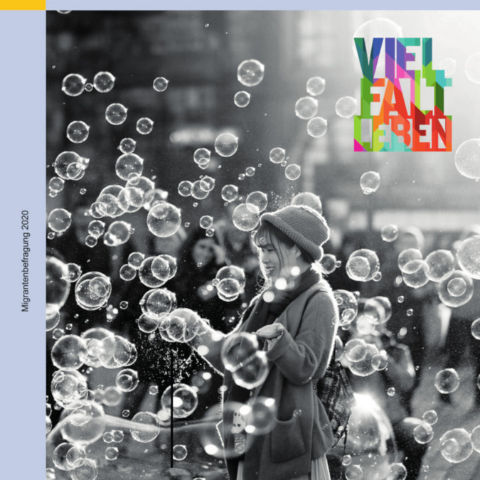 Titelbild Migrantenbefragung. Eine junge Frau mit vielen Seifenblasen und dem bunten Logo Vielfalt leben