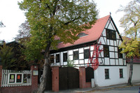 Frontansicht des bewachsenen Fachwerkhauses Geyser Haus