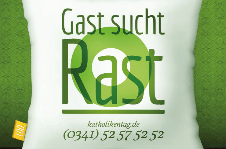 Grüne Schrift auf weißem Kissen vor grüner Wand: Gast sucht Rast. katholikentag .de