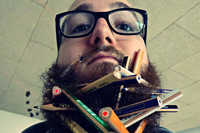 Gesicht eines jungen Mannes mit vielen Stiften im Bart