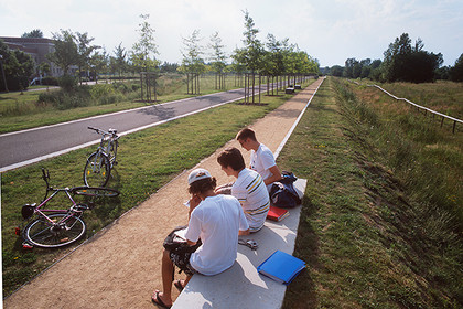 Jungendliche auf eine Steinbank am Fahrradweg im Grünen Bogen Paunsdorf