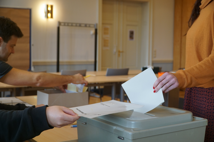 Eine Wählerin wirft im Wahllokal ihren Stimmzettel in eine Wahlurne ein.