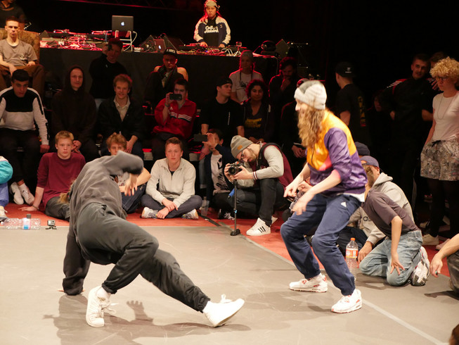 Zwei junge Leute führen Hip Hop Tänze vor einem jungen Publikum vor